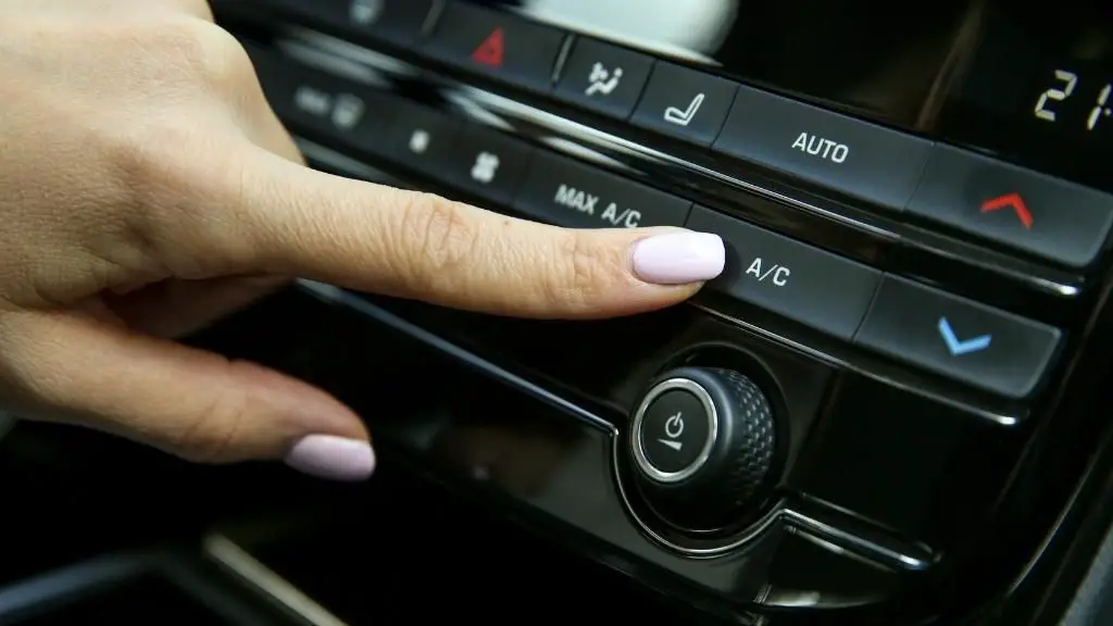 female hand with pink nails pointing on car AC button